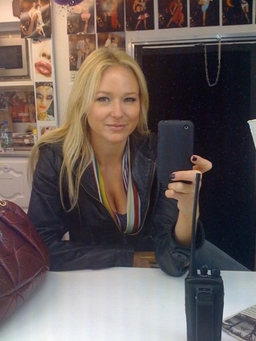 young teen girl taking pictures in a mirror with iphone