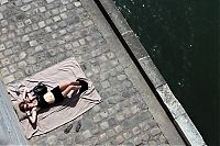 People & Humanity: Parisian girl sunbathes on the Seine river bank