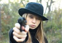 People & Humanity: cute young blonde girl shows her long hair with gun