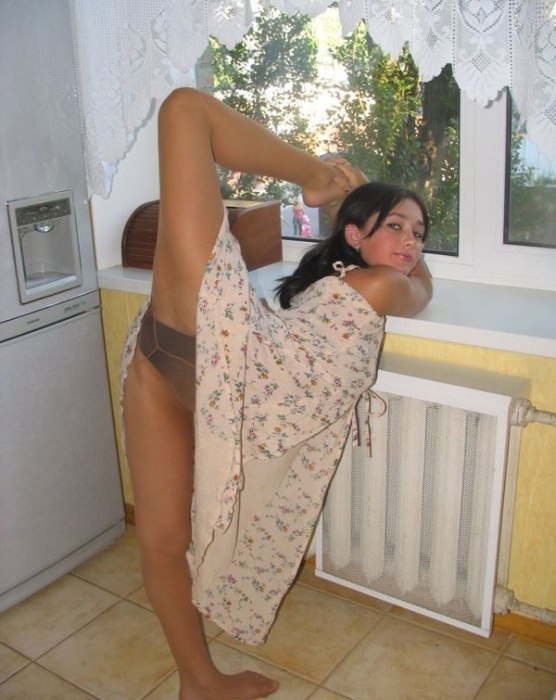 young brunette girl doing flexible gymnastics at home