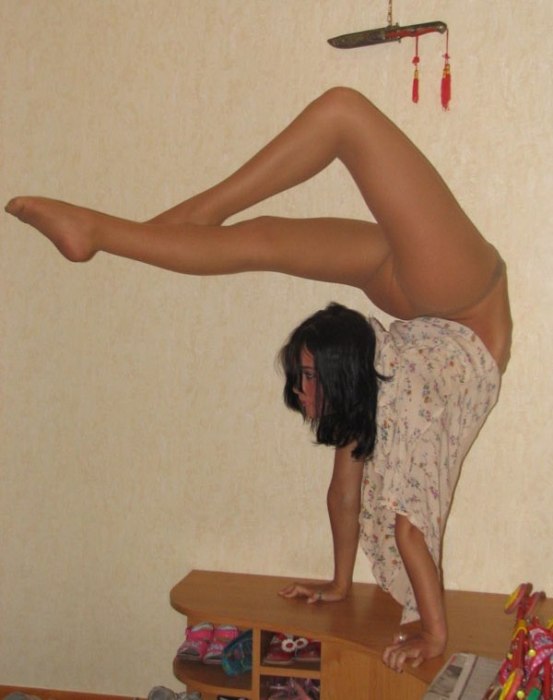 young brunette girl doing flexible gymnastics at home