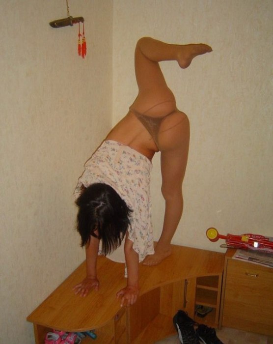 young brunette girl doing flexible gymnastics at home