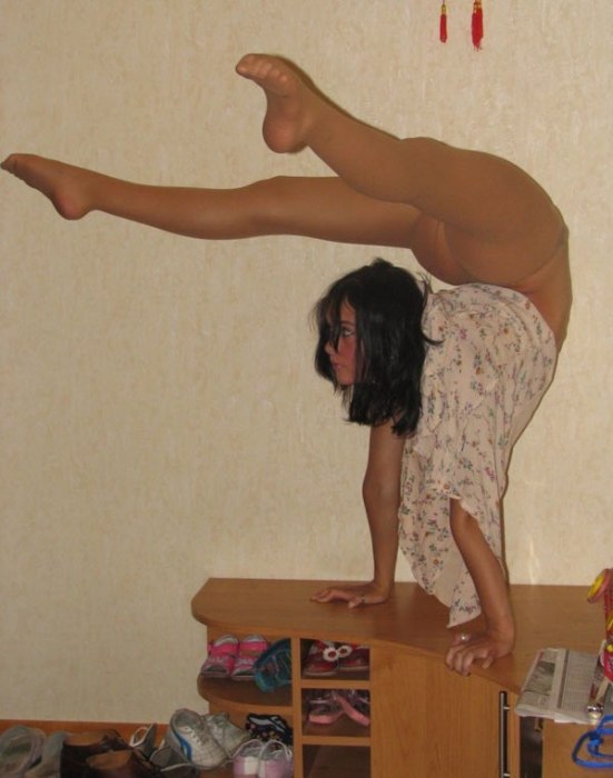 young brunette girl doing flexible gymnastics at home