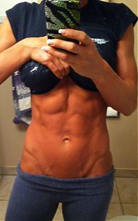 Sport and Fitness: strong fitness bodybuilding girl with abdominal six-pack belly muscles